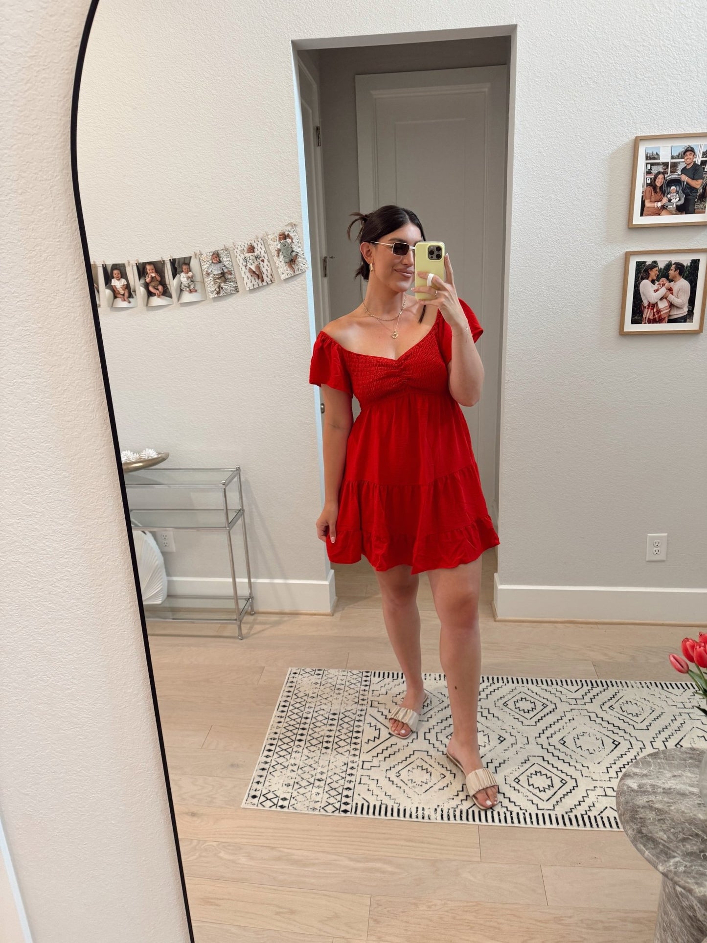 Woman snaps a mirror selfie in the Ava's Sweetheart Red Mini Dress - DOORBUSTER, sandals, and a bright room with family photos.