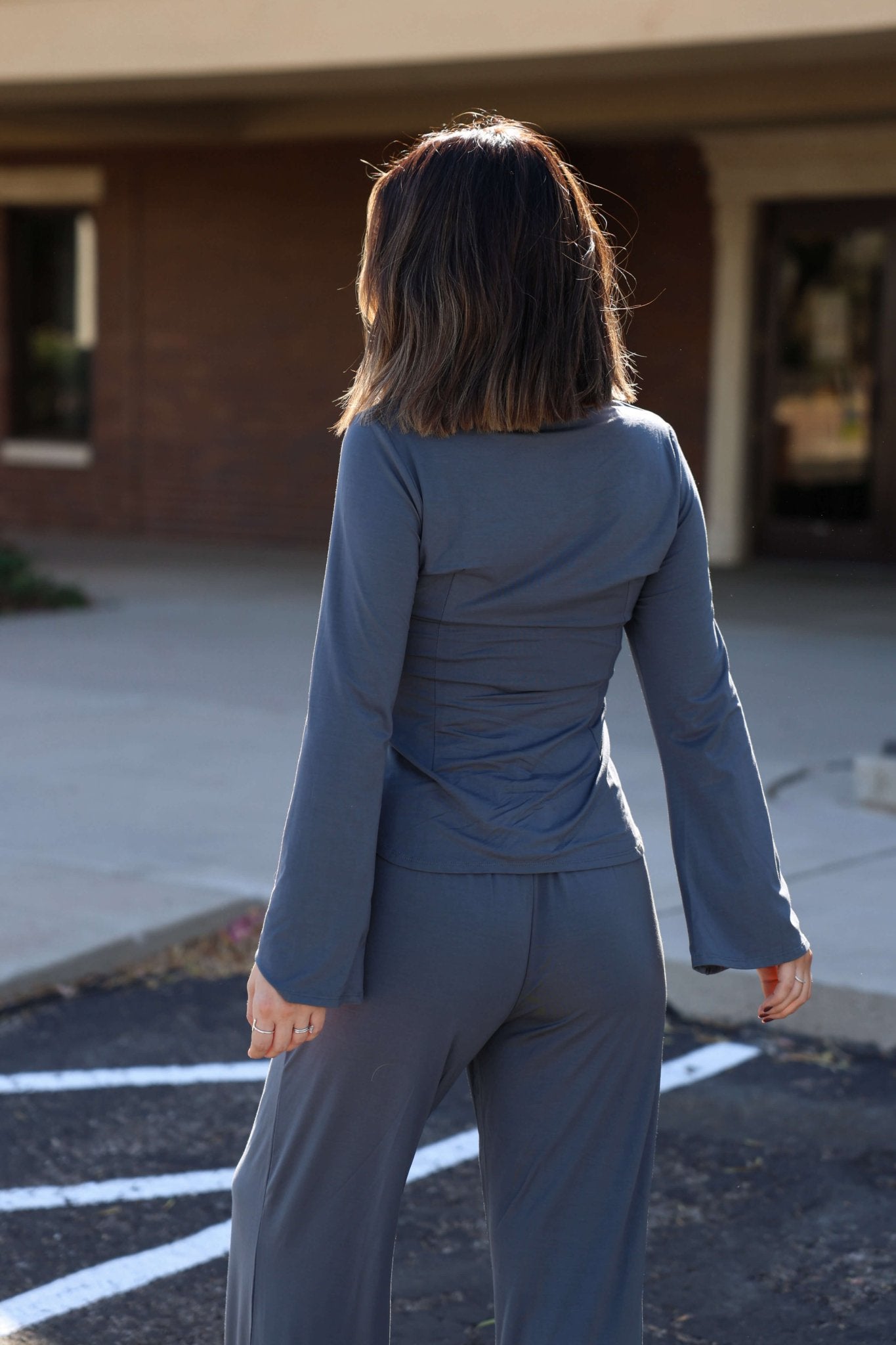 Wearing the Elan Grey Half Button Up Top - FINAL SALE, someone stands outdoors, capturing effortless fall style.