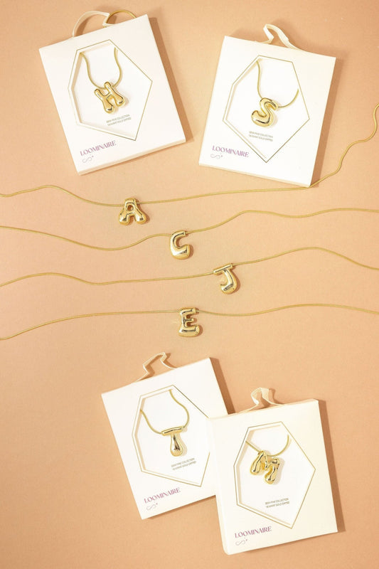 Gold Dipped Bubble Letter Pendant Necklace - FINAL SALE, with 18k gold initials: H, S, A, G, J, E, T & M on display cards.
