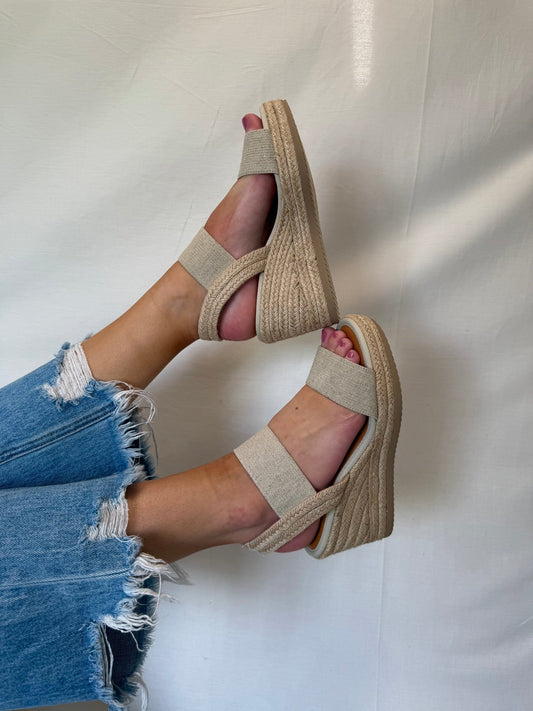 Person wearing MIA Brittni Natural Wedge Espadrille Sandals with frayed blue jeans against a plain light background.