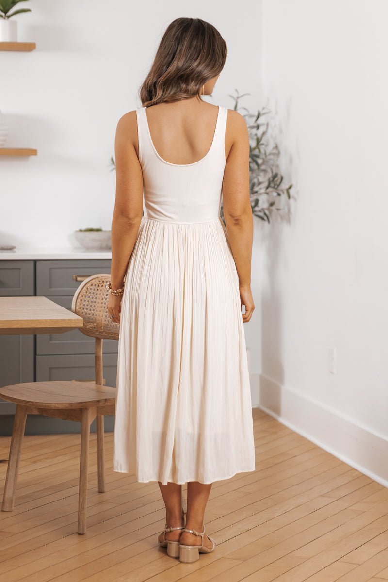 Woman with long hair models the Scoop Neck Pleated Skirt Midi Tank Dress - FINAL SALE, back facing the camera.