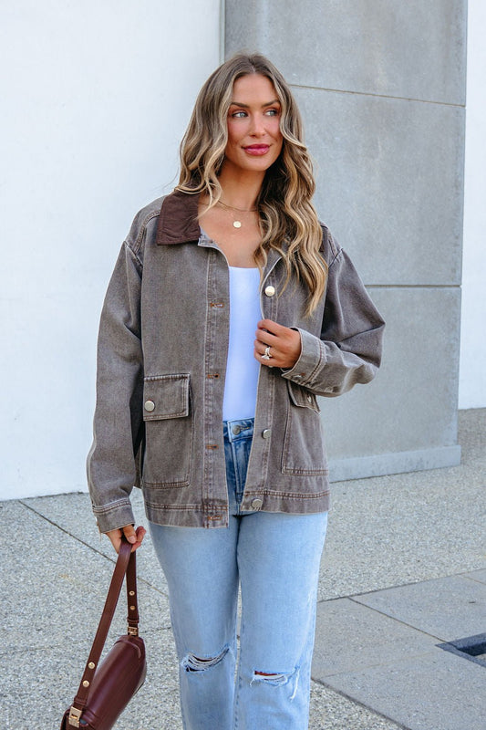 A woman wearing a brown Twill Barn Jacket with a corduroy collar over a white top and blue jeans.