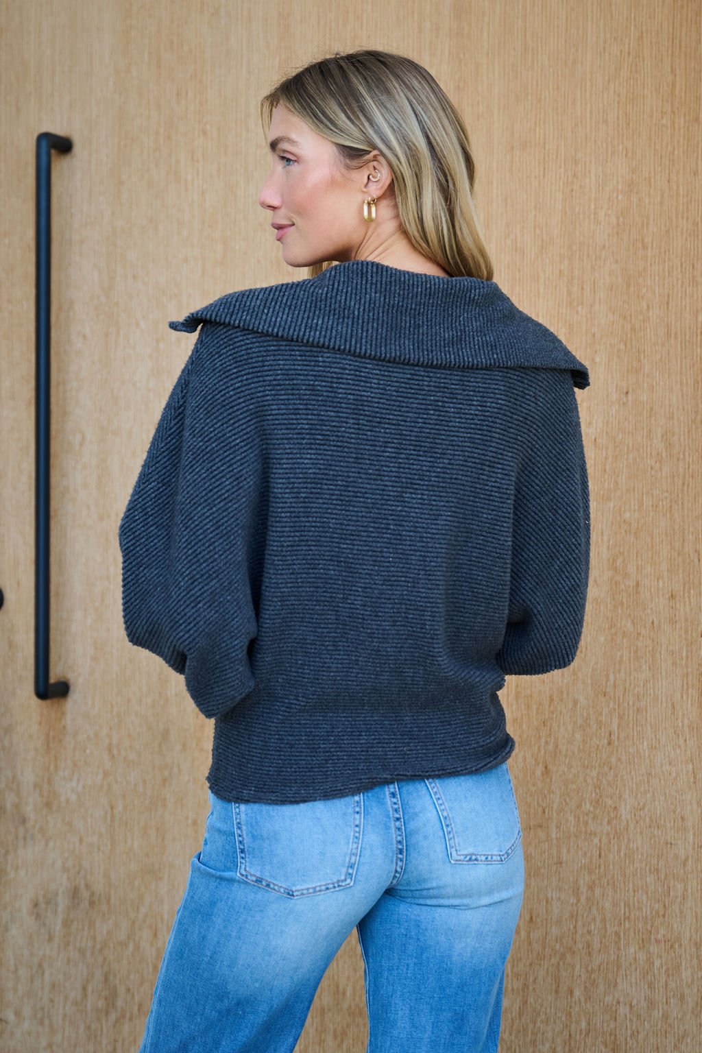A woman with long blonde hair wears the Ultra Soft Charcoal Collared Pullover and light blue jeans, showcasing her cozy winter style.