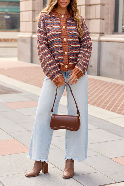 Woman in a Multi Striped Button Down Sweater, wide-leg jeans, brown boots, and handbag walking on a city sidewalk.