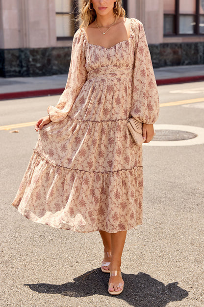Woman wears Sweetheart Floral Print Midi Dress - Sand, holding her skirt and a woven clutch on a sunlit street.