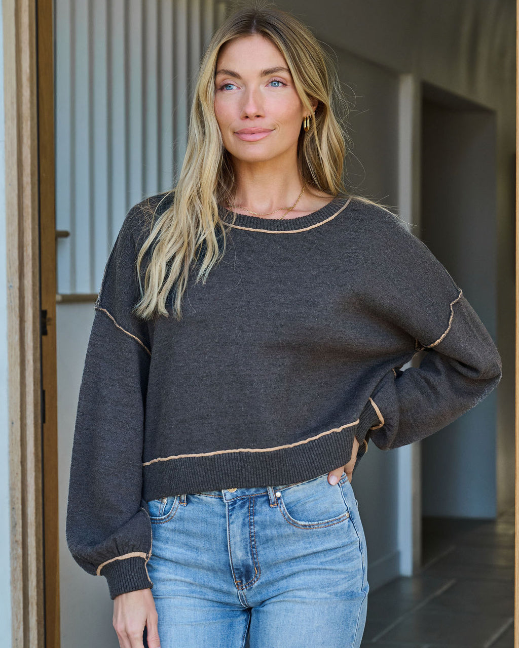 Alden is standing outdoors wearing our Charcoal_Contrast_Seam_Detail_Pullover