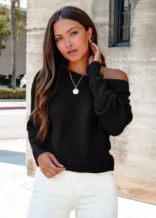 Britt is standing outdoors wearing our Cozy_Ribbed_Boat_Neck_Sweater_-_Black