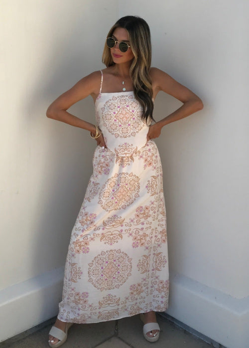 Woman wearing a floral dress against a white wall