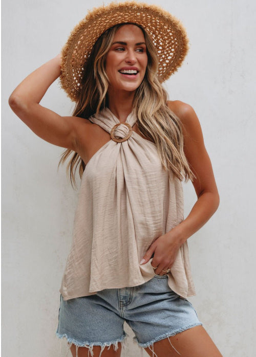 Woman wearing a straw hat, beige top, and denim shorts against a white background