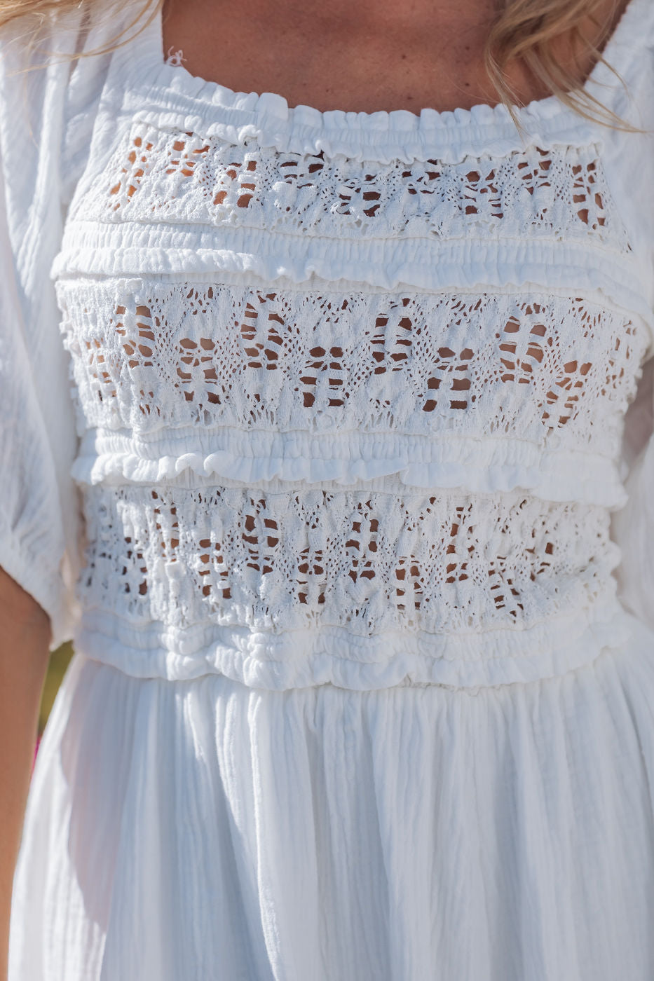 Close-up of the Angelica White Ruched Midi Dress, featuring puff sleeves, gathered chest, and intricate lace detailing.