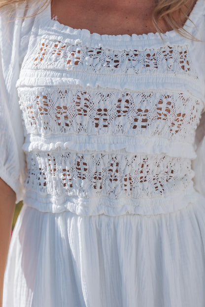 Close-up of the Angelica White Ruched Midi Dress, featuring puff sleeves, gathered chest, and intricate lace detailing.