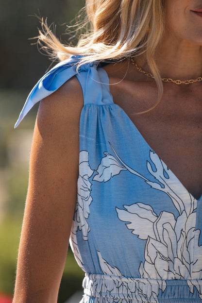 Woman in a Light Blue Print Tie Strap Midi Dress, standing outdoors in sunlight.
