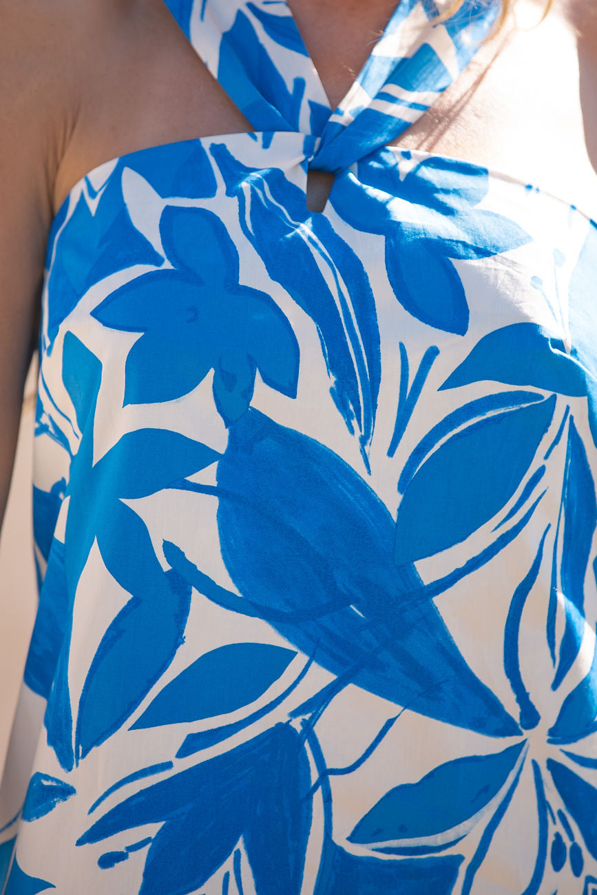 Close-up of a person wearing the Azure Blue Print Halter Mini Dress, highlighting the floral pattern and halter neckline.
