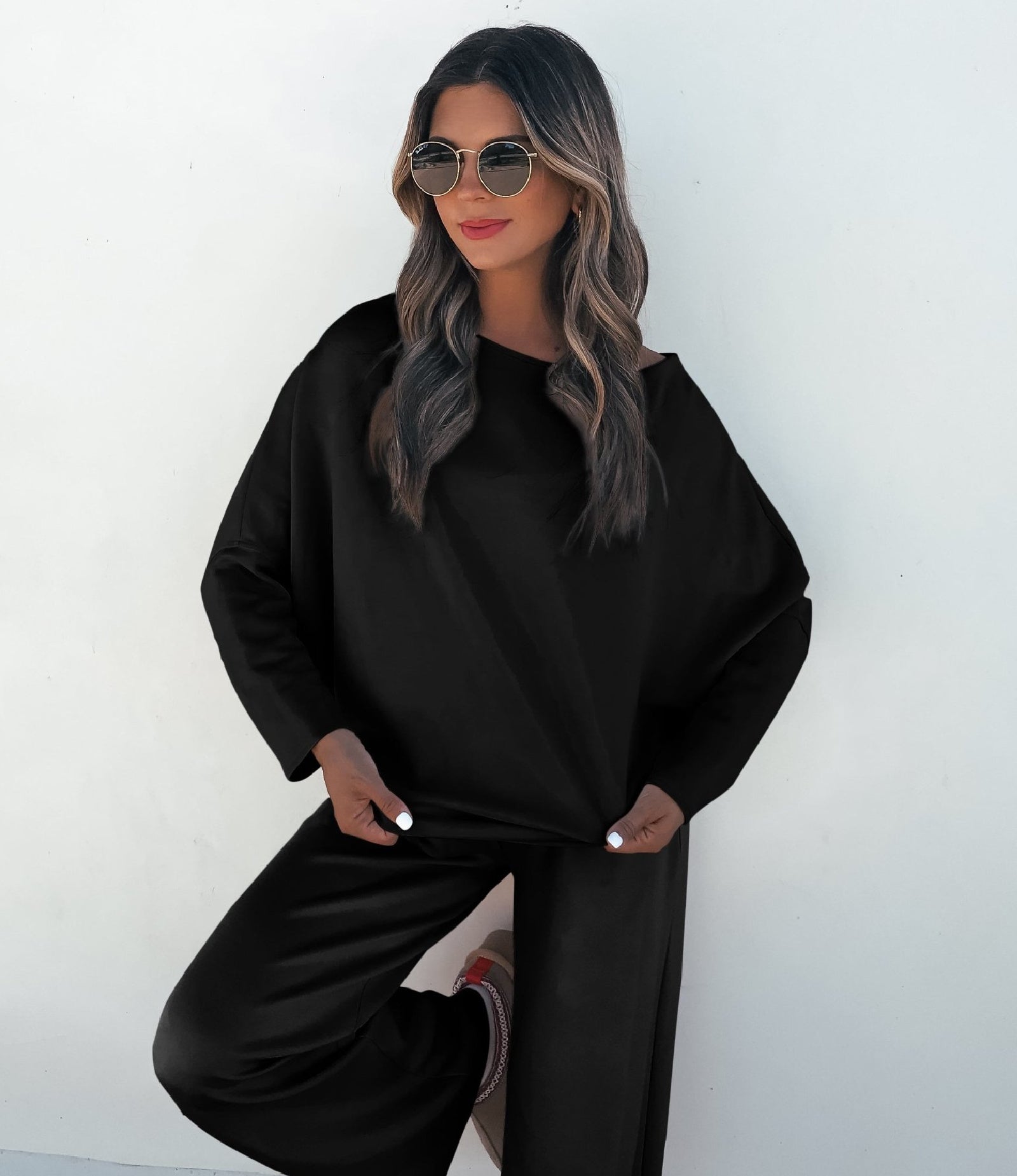 Woman wearing a black outfit against a white background