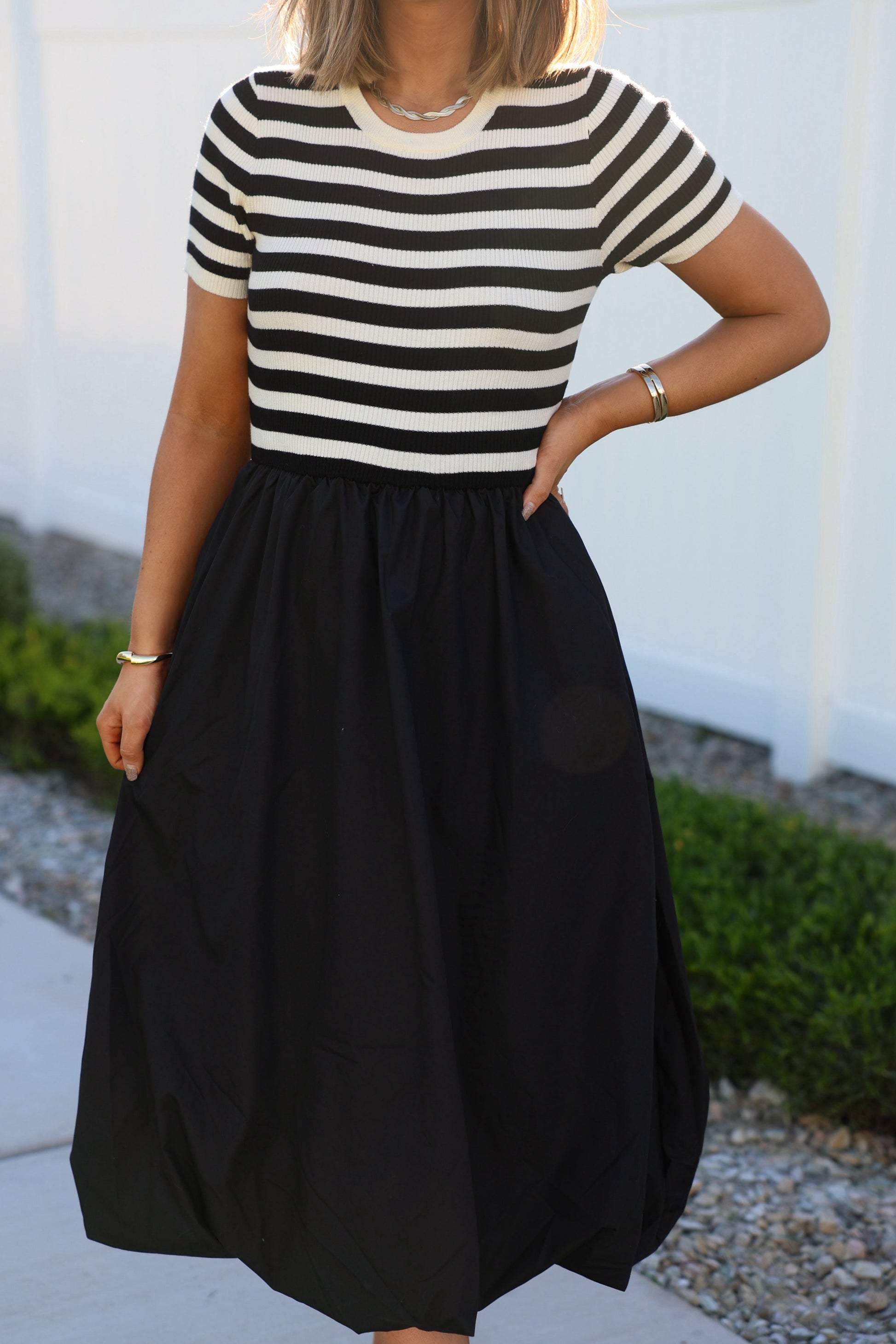 Woman wearing a Black Stripe Bubble Hem Midi Dress outdoors.