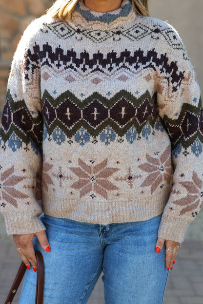 A person wears a Light Khaki Fair Isle sweater in beige with a brown, blue, and cream geometric pattern and a mock-neck.