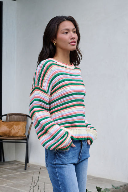 Woman standing outside in the Ivory Multi Striped Crewneck Sweater and blue jeans, perfect for your winter wardrobe.
