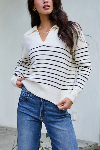 Model wears the Ivory and Black Stripe Ribbed Sweater with blue jeans—ideal for your winter wardrobe.