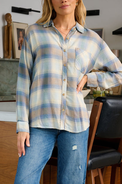 A woman wears a Blue Plaid Button Down Flannel Shirt and ripped jeans, standing confidently in a modern kitchen.