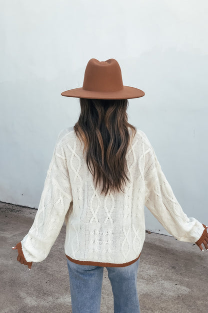 Person wearing the Cream Contrast Trim Cardigan, brown hat, and jeans stands with back to camera against a plain wall.