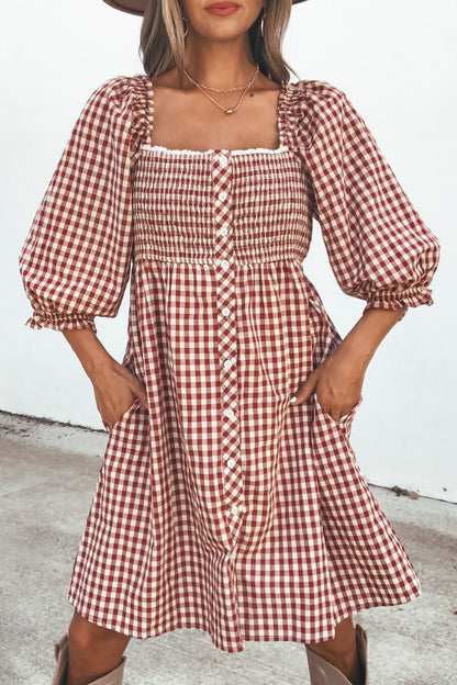 Woman in a Gingham Babydoll Mini Dress - Burgundy, featuring puff sleeves, mini length, and pockets, standing outdoors.