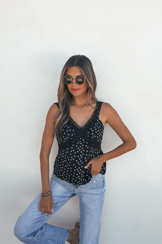 Woman wears sunglasses, the Midnight Lace Print Tank Top - Black, and light blue jeans against a plain white background.