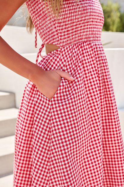 Woman wearing a Gingham Open Back Maxi Dress - Red, standing outdoors by light-colored stairs.