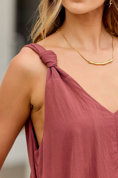 Woman wearing the Audrey Knot Strap Midi Dress in burgundy, featuring knotted straps, styled with a gold necklace.