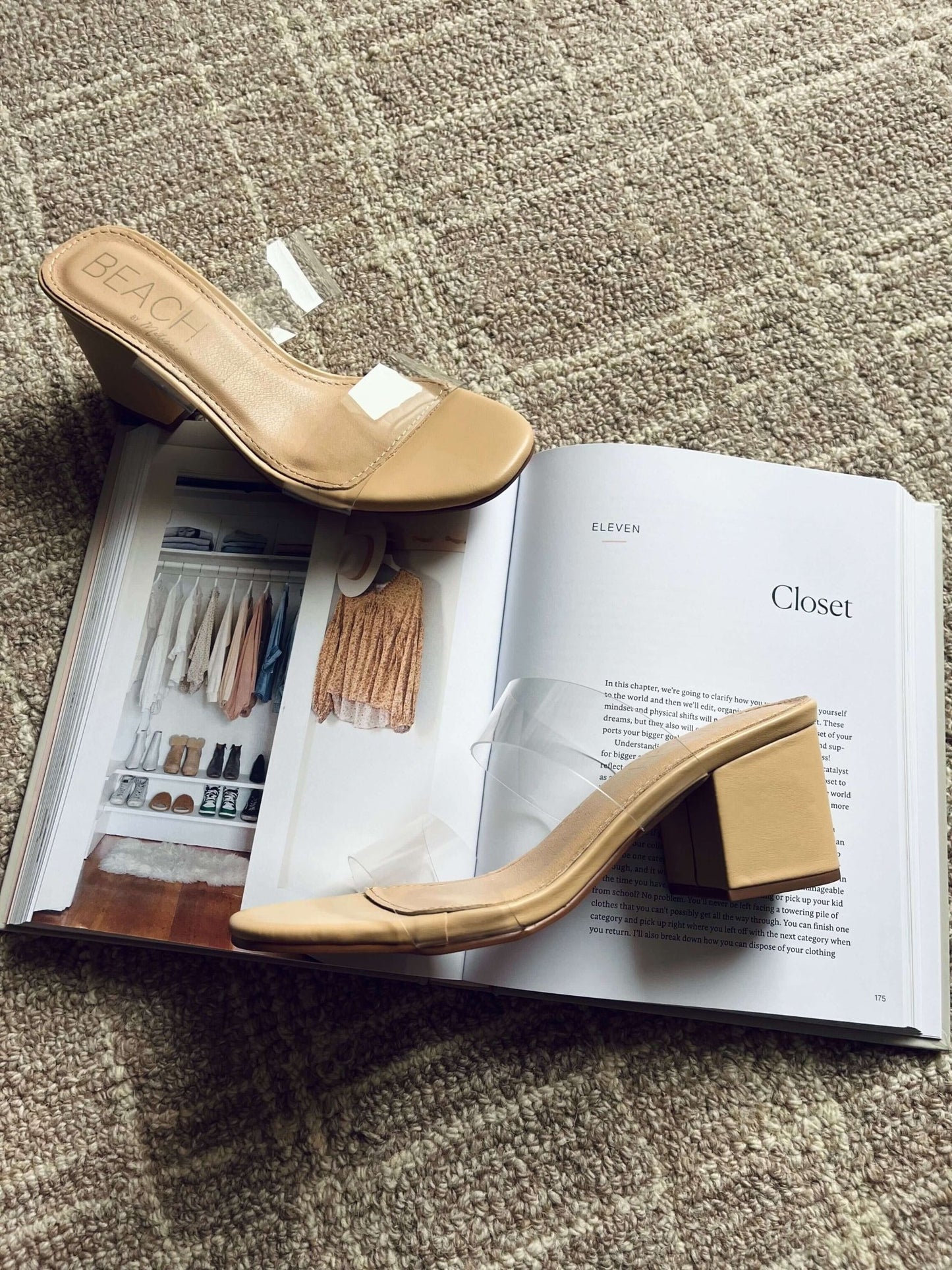 Two Beach by Matisse Aura Nude Strappy Heels rest on an open book titled "Closet" atop a textured carpet.