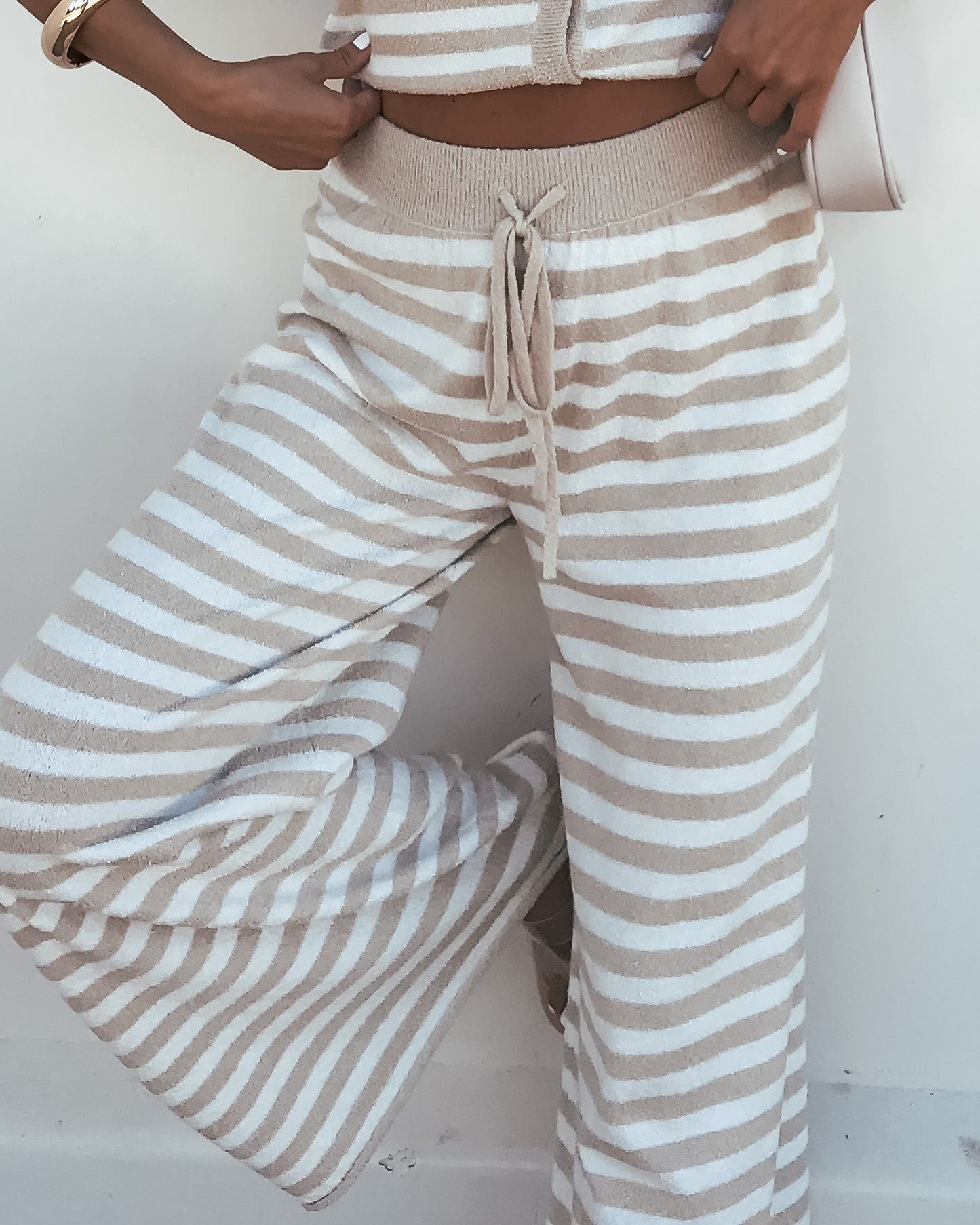 Model wears Beige and Ivory Striped Lounge Pants (Pre Order) with a matching cropped top, hand on hip.