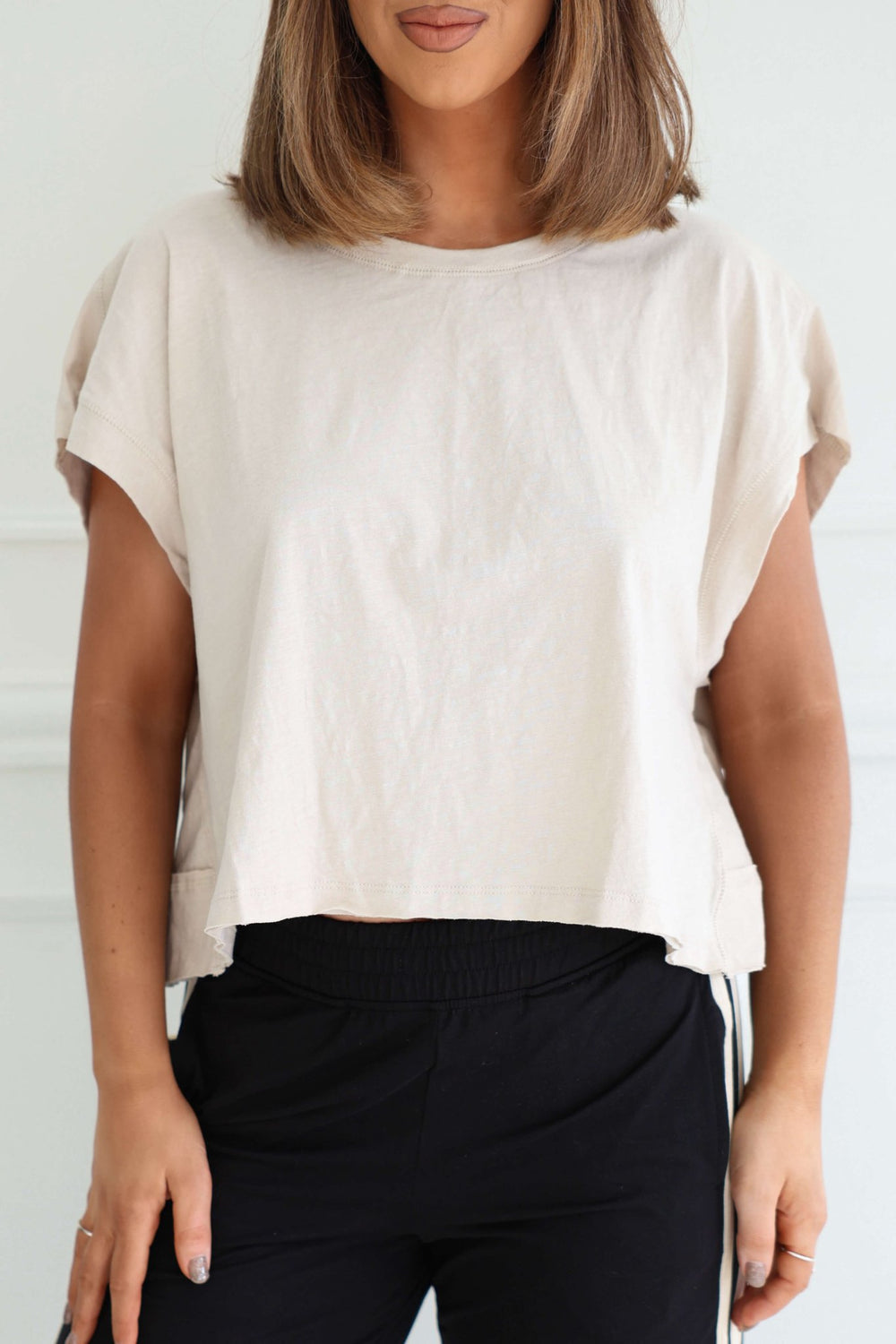 Woman models the Beige Cotton Slub Open Back Top - FINAL SALE with black pants against a white background.