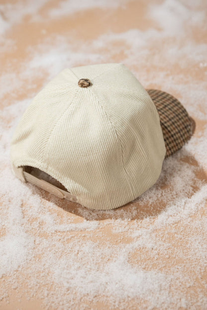 The Beige New York Corduroy Baseball Hat rests on a light surface dusted with white powder.