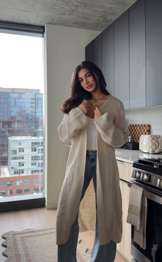 Woman wearing a beige ribbed open-front duster cardigan.