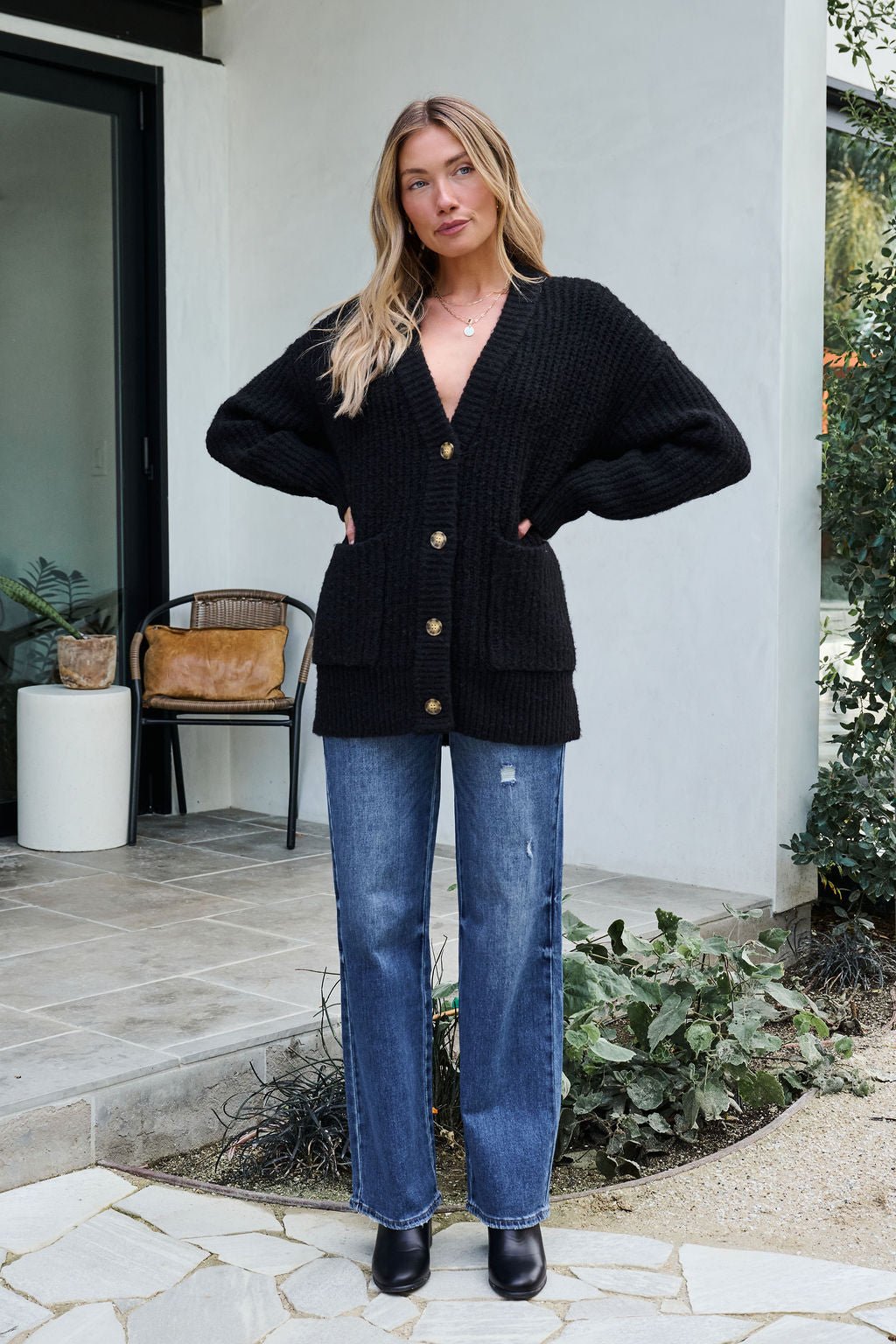 Woman outdoors in a Basic Black Knit Button Down Cardigan—stylish for updating your winter wardrobe.