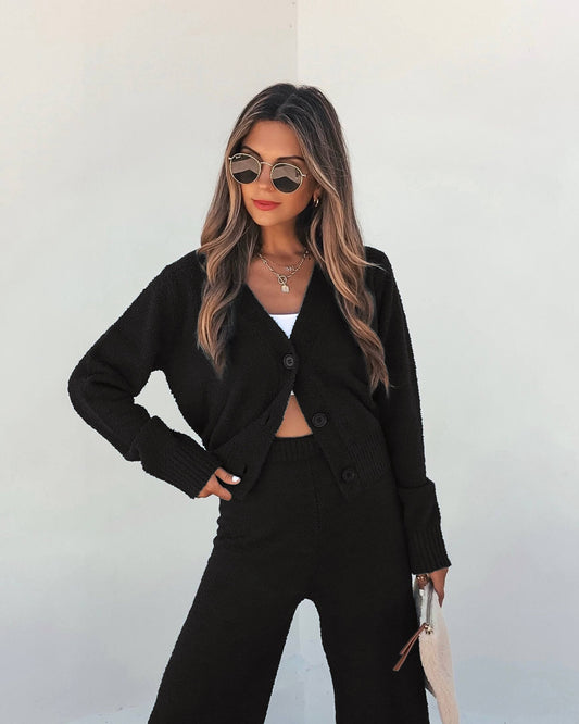 Woman in a Black Sherpa Lounge Set - FINAL SALE, styled with sunglasses, red lipstick, and a white clutch.