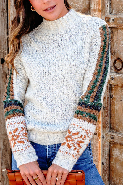 Woman in the Blaire Oatmeal Fair Isle Sweater, holding a brown clutch by a wooden door—perfect for fall style.