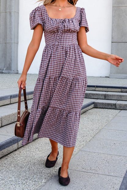 Woman in a BLU PEPPER B6FD1108 mocha midi dress, holding a brown purse, walks outside on stone steps.