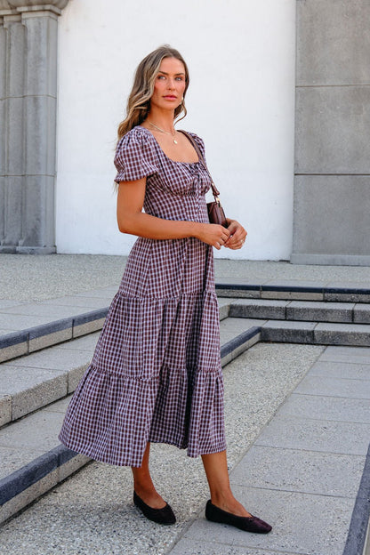 Woman in a BLU PEPPER B6FD1108 MOCHA MIDI DRESS and black flats stands outdoors on stone steps, looking at the camera.