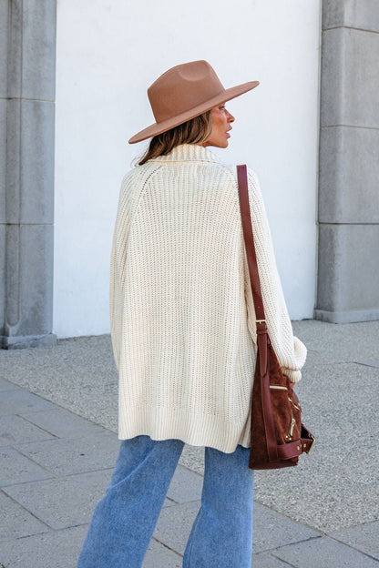 Woman outdoors in a beige wide-brim hat, blue jeans, and BLU PEPPER J6FJ1011 IVORY SWEATER with a brown shoulder bag.