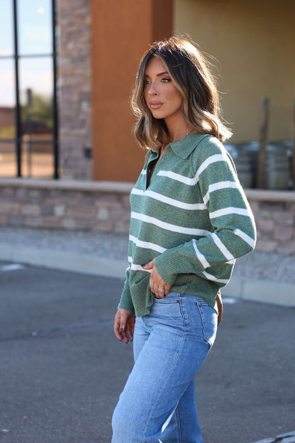 Woman wearing the Brinkley Sage and White Striped Sweater with blue jeans, perfect for a cozy fall look outdoors.