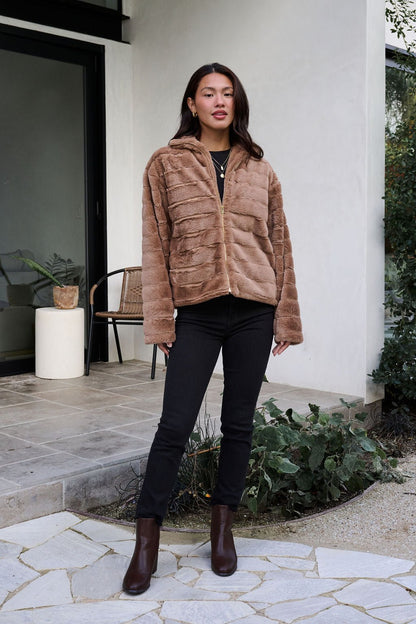 A woman models the Brown Faux Fur Zip Collared Jacket outdoors, highlighting its cozy style.