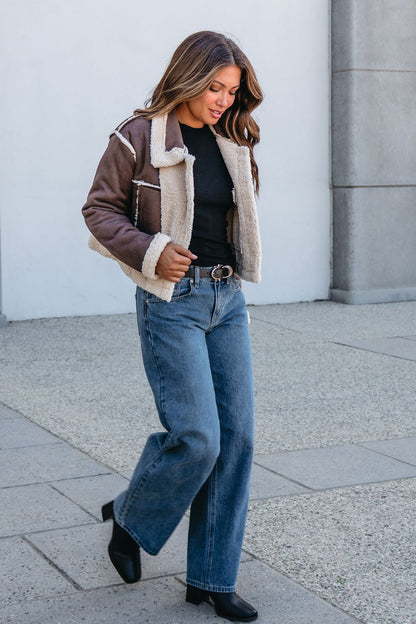 Woman walking outside in the Brown Mix Reversible Suede Sherpa Jacket—an essential that elevates fall jeans and boot looks.