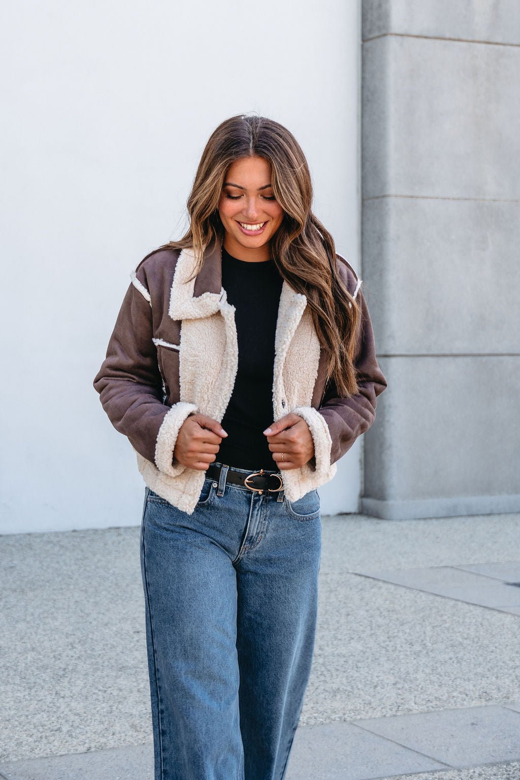 Smiling woman with long brown hair in the Brown Mix Reversible Suede Sherpa Jacket—a cozy, stylish fall cold-weather essential.