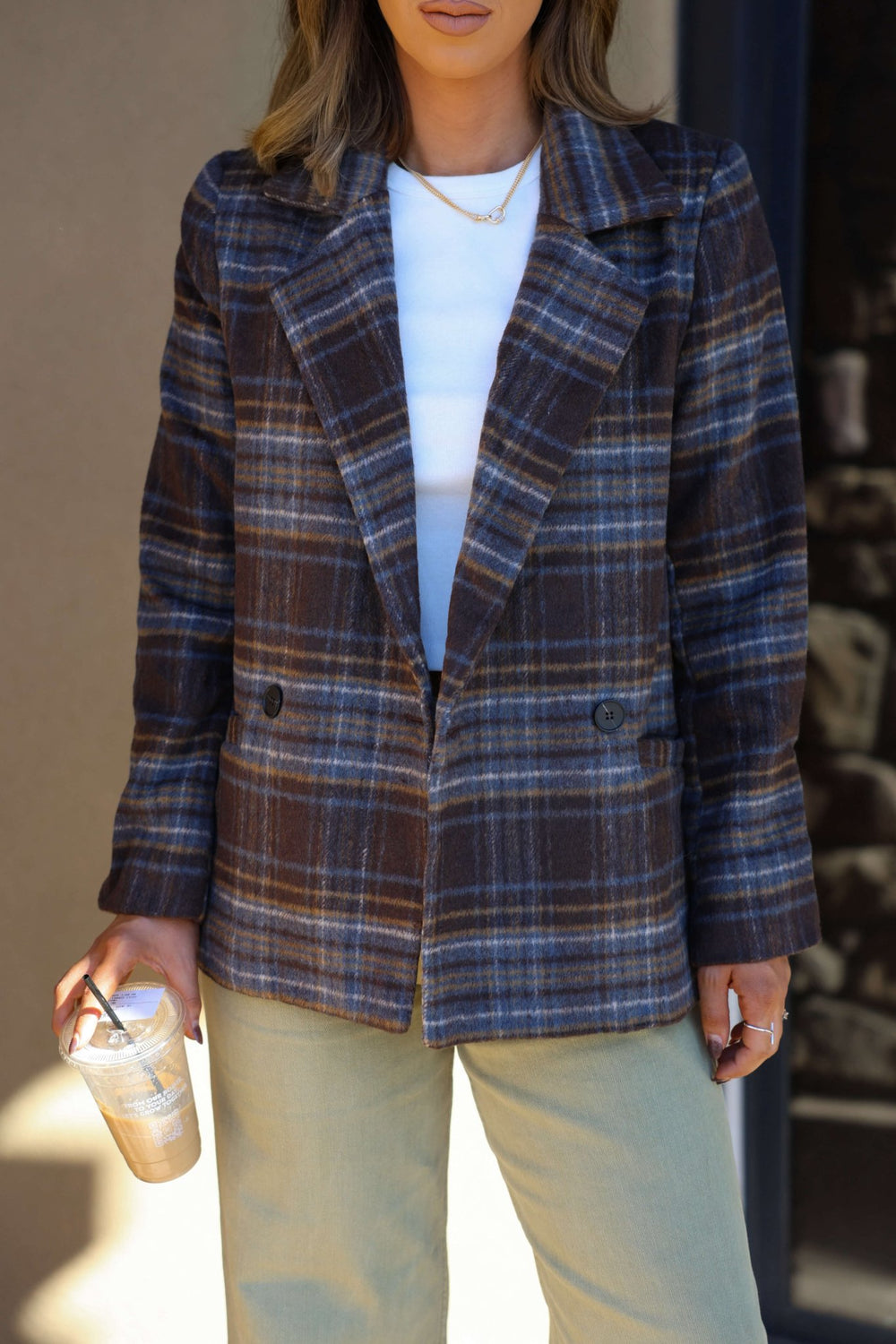 Woman in Brown Plaid Blazer Jacket - FINAL SALE, wearing a white top and holding an iced coffee.