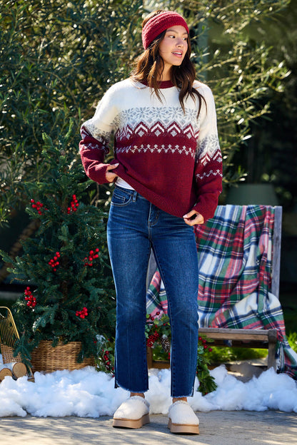 Woman in a Burgundy Mix Fair Isle Sweater stands outdoors by a plaid blanket and festive greenery.