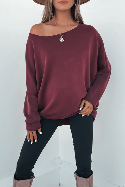 Woman wearing a Burgundy Soft Cloud Scuba Pullover, black pants, taupe boots, brown hat, and round pendant necklace.