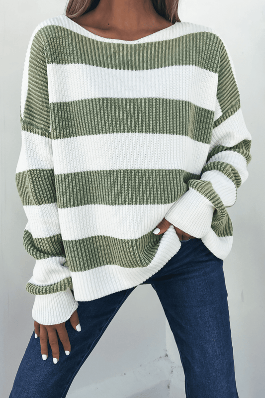 Person in a Callahan Green and White Striped Sweater and blue jeans, standing with one hand in their pocket.