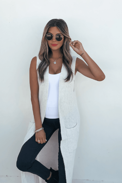 Woman in sunglasses styles the Champagne Open Front Long Cardigan over a white top and black pants for chic fall layering.