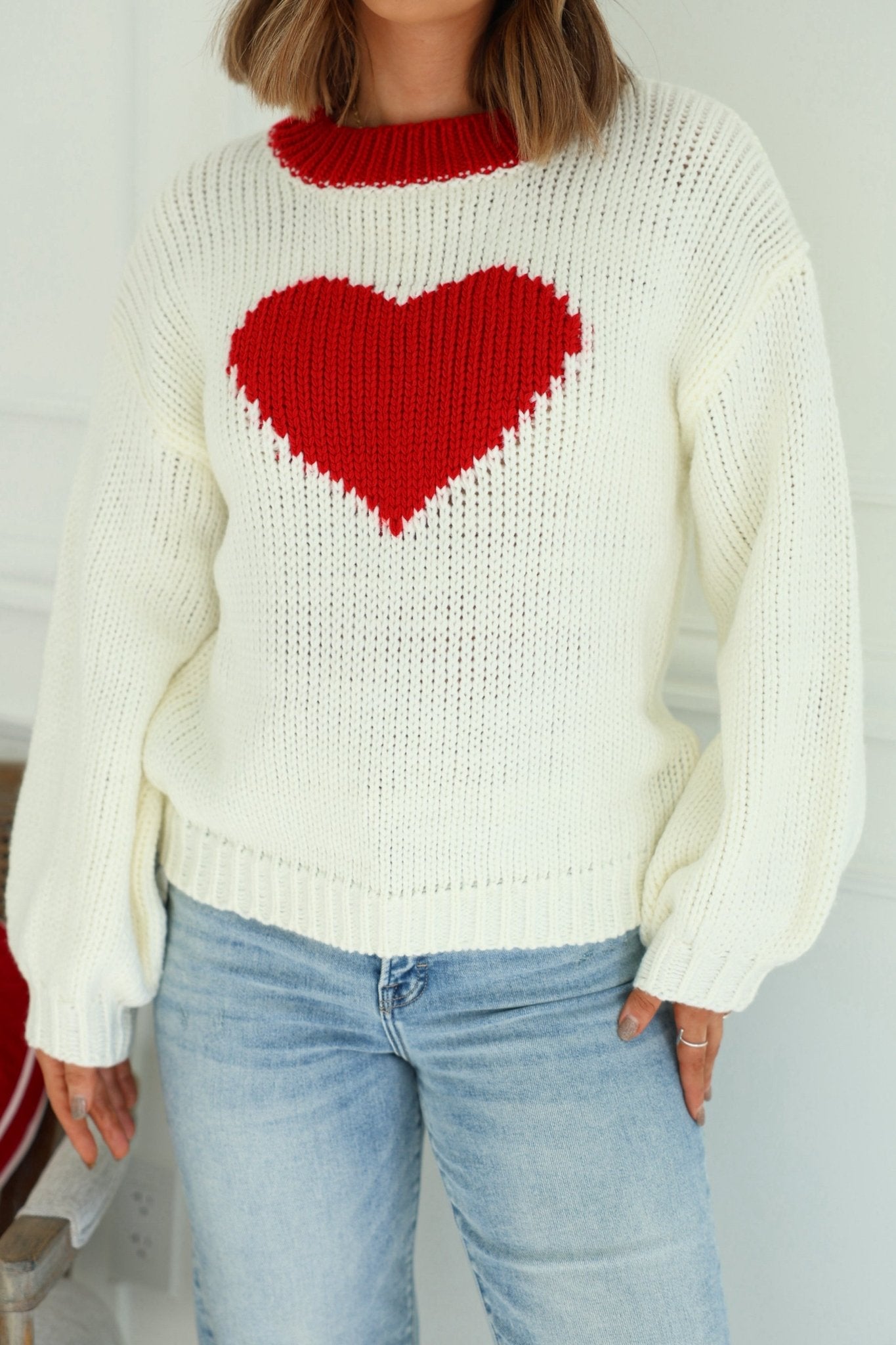 Model wearing the Chunky Cream Heart Shape Sweater, styled with light blue jeans.