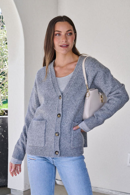 A woman wears a Cozy Grey Boyfriend Cardigan.
